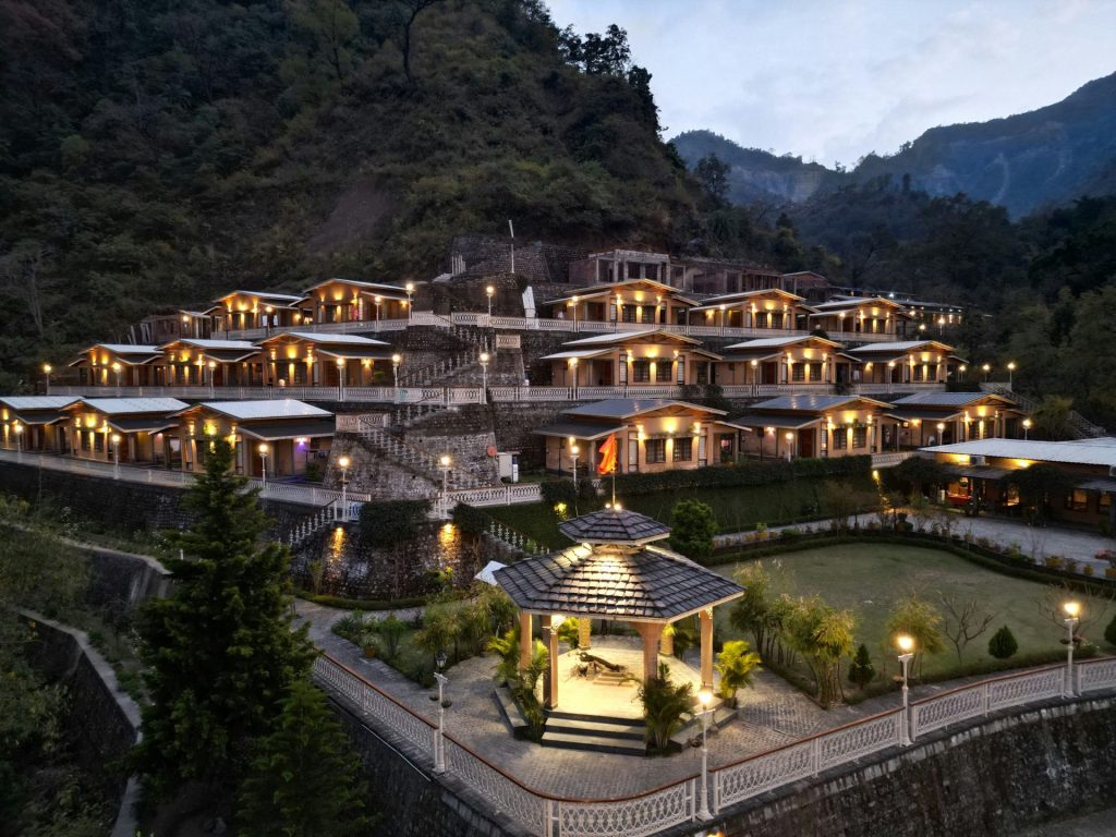 Complejo turístico enclavado en la ladera de una montaña con edificios iluminados.